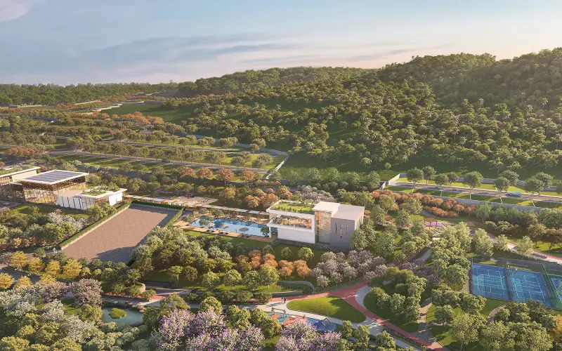 Aerial view of the courts, pool and central greens below the forested hills